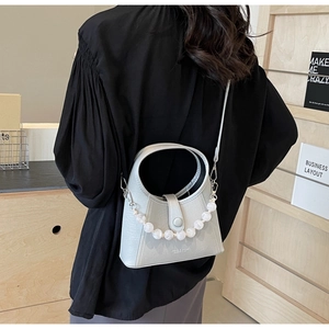 Detail of light grey beaded handbag featuring pearl chain and matte leather texture