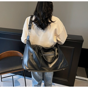 Vue arrière d'un grand sac fourre-tout noir minimaliste avec bandoulière réglable