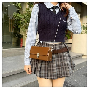 Brown vintage box bag with silver buckle worn over a preppy style outfit