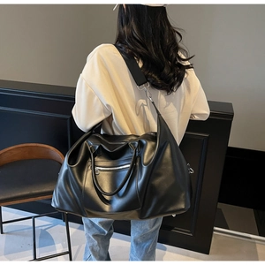Détail du sac de voyage noir avec ferrures en métal argenté et bandoulière