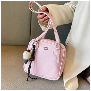 Detail of a pink leather square handbag with CON ZON logo and plush ice cream charm decoration
