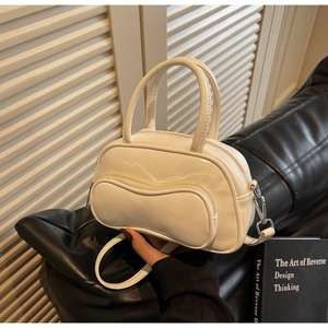 Détail du sac Boston blanc brillant avec coutures ondulées et poche zippée argentée