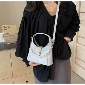 Detail of light blue beaded handbag with semi-circular handle and ivory pearl chain