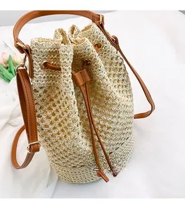 Detail view of woven bucket bag with cream mesh texture and brown leather drawstring strap