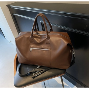 Détail du sac de voyage en cuir PU marron foncé avec poche zippée et bandoulière