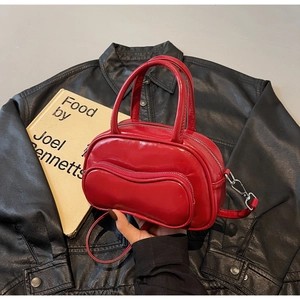 Détail du sac Boston en cuir brillant rouge avec poche zippée ondulée unique