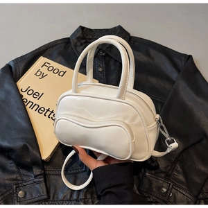 Détail du petit sac Boston blanc avec poche zippée ondulée et finition brillante