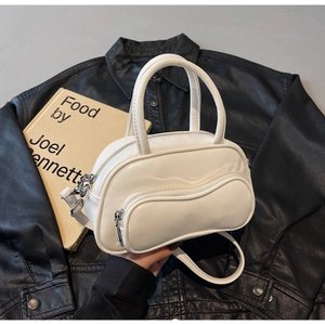 Détail du sac Boston en cuir PU blanc avec poche zippée ondulée sur une veste noire