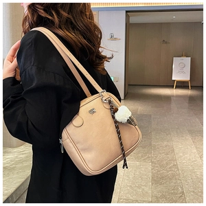 Detail of beige square shoulder bag with plush ice cream charm and metal logo lettering
