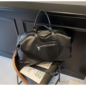 Détail du sac de voyage noir mat avec fermetures argentées et bandoulière amovible