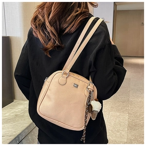 Detail of beige faux leather handbag with ice cream charm and slim shoulder straps