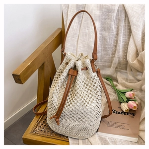 Detail of hollow-out woven bucket bag with leather drawstring and textured fabric lining