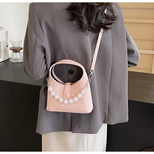 Detail of pink leather bucket bag with pearl handle worn with grey blazer