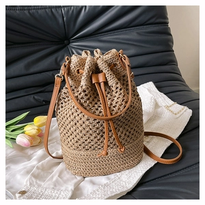 Close-up of the hollow woven mesh and drawstring detail on this summer straw bucket bag