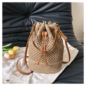 Detailed close-up of woven bucket bag with leather drawstring and elegant gold hardware