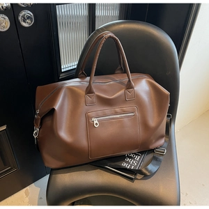 Sac de voyage en similicuir marron sur une chaise moderne avec grande capacité