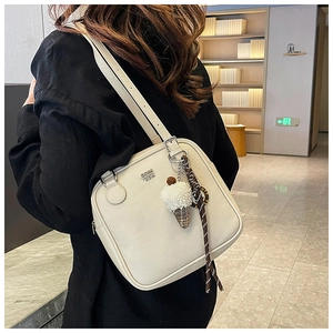 Detail of cream white leather shoulder bag with silver logo and plush ice cream charm