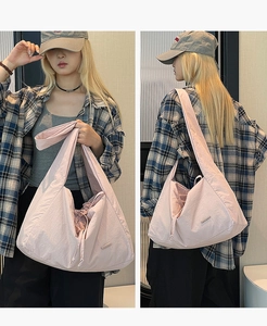 Detail view of pink nylon tote bag with drawstring closure and wide shoulder strap
