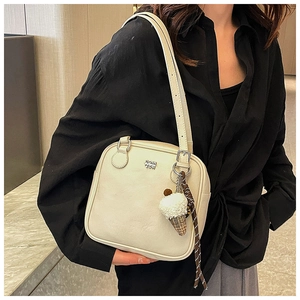 Detail of cream square shoulder bag featuring metal logo and plush ice cream charm