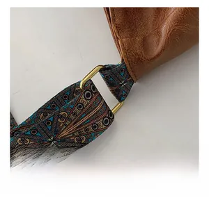 Detail of brown lychee leather and colorful woven strap with gold metal ring