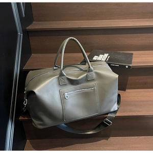 Détail du sac de voyage vert olive avec texture en cuir PU mat et poignées robustes