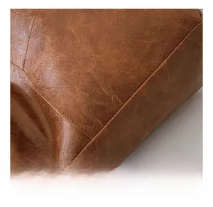Detailed macro shot of vintage brown leather texture and premium stitching on a tote bag