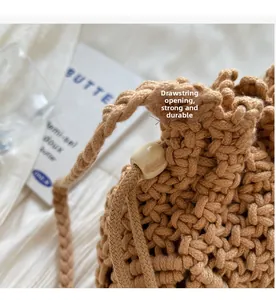 Detail of khaki crochet bucket bag with drawstring closure and decorative wooden bead
