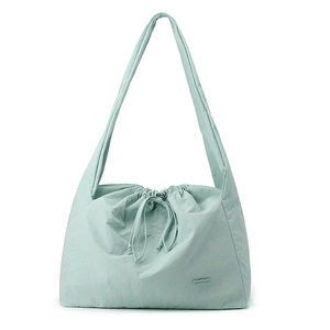Detail of mint green nylon shoulder bag showing pleated texture and drawstring closure