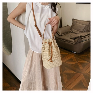 Macro detail of hand-woven straw bucket bag with mesh texture and leather drawstring