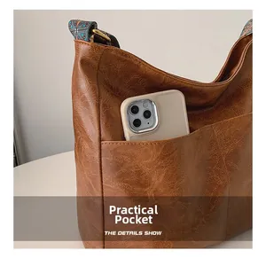 Brown vintage faux leather tote with practical front pocket for phone and ethnic strap