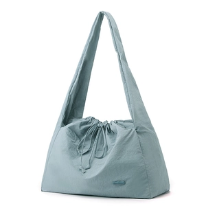 Detail of grey-blue nylon tote bag showing drawstring closure and micro-wrinkle texture