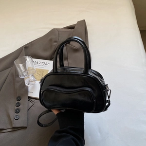 Glossy black Boston shoulder bag with silver zipper in a minimalist modern aesthetic