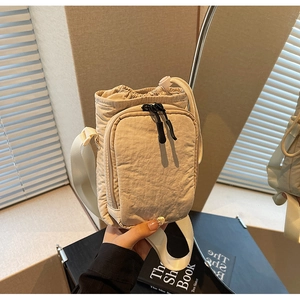 Detailansicht der cremefarbenen Nylontasche mit Kordelzug und praktischen Doppelreißverschlüssen