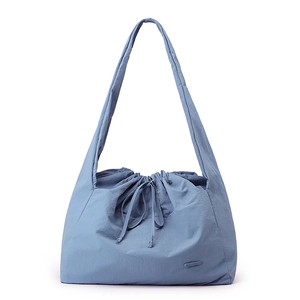 Detail of blue waterproof nylon handbag showing functional drawstring closure and fabric texture