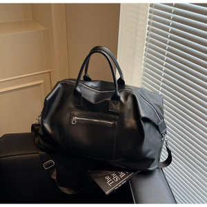 Détail du sac de voyage en cuir noir avec poche zippée et bandoulière amovible