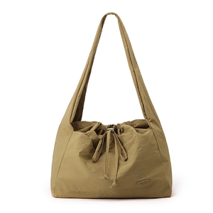 Close-up of waterproof nylon tote with drawstring closure and bow detail in khaki