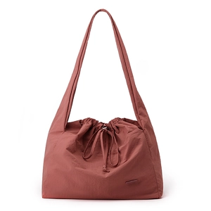Detail of waterproof nylon tote bag in burgundy with pleated texture and drawstring