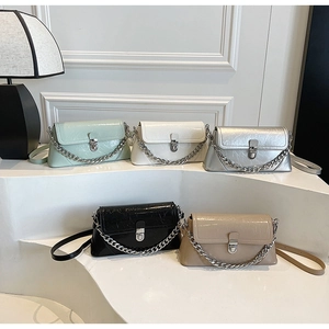 Five colored pleated patent leather crossbody bags with silver chain handles and metal clasps