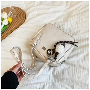 Detail of off-white square shoulder bag with plush ice cream charm and metal logo
