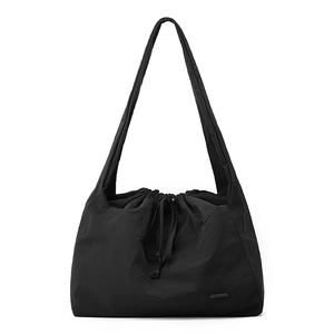 Detail of black nylon tote bag with drawstring closure and ruched texture finish