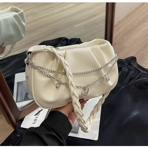 Détail d'un sac nuage plissé blanc cassé avec double chaîne en métal et pendentifs