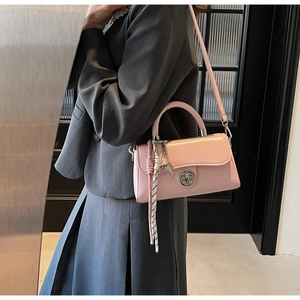 Detail van de roze crossbodytas met zilveren draaisluiting en veerhangertje