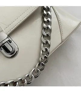 Close-up of vintage textured leather handbag with silver twist lock and thick chain strap