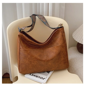 Detail of vintage brown hobo bag with ethnic print wide strap and gold hardware accents