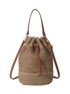 Large woven straw bucket bag with brown leather straps for beach holidays and vacations