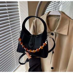 Detail view of black beaded handbag with amber beads and adjustable strap
