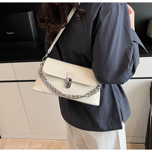 Modern cream shoulder bag featuring silver chain detail and sleek metal lock closure
