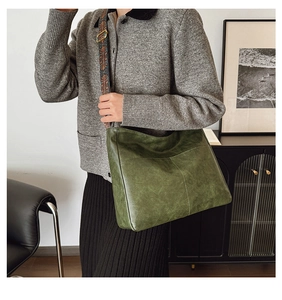 Detail of dark green vintage tote bag with ethnic pattern wide woven shoulder strap