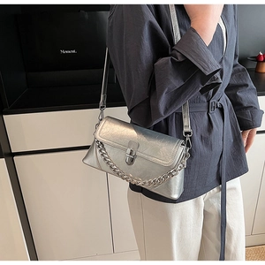 Close-up of metallic silver crossbody bag with leather texture and thick chain detail