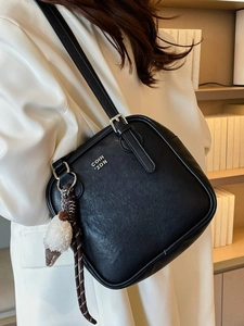 Retro black leather shoulder bag with metallic logo and plush charm accessory